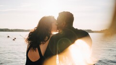 Couple kissing on the beach at sunset