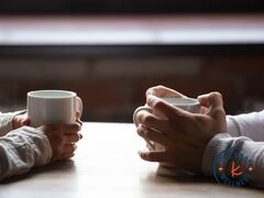 Couple holding hands holding cups of coffee