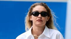 Gigi Hadid flashes her toned midriff in a white shirt and flared ...