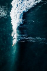 A person riding a surfboard on a wave in the ocean photo – ...