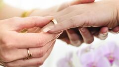 Couple holding hands with wedding rings