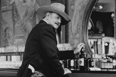 John Wayne in The Shootist Iconic Pose at Saloon Bar Whisky Bottle Gun Belt (John Wayne)