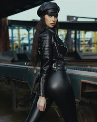 woman in black leather jacket and black pants wearing black hat ...